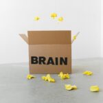 brain inscription on cardboard box under flying paper pieces