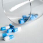 depth photography of blue and white medication pill